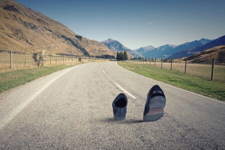 Pair of black shoes walking on roadの写真素材