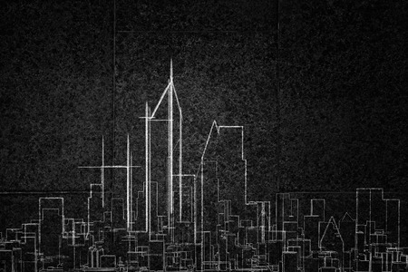 Close up of hand drawing urban city building on chalk boardの写真素材