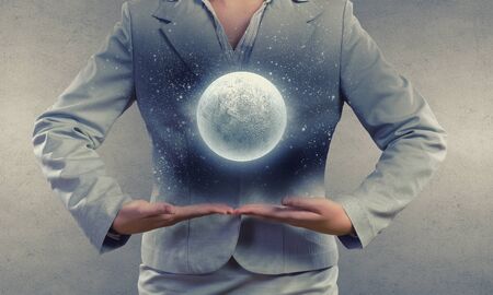 Close up of businesswoman holding in hands full moonの写真素材