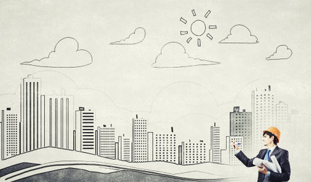 Young man engineer in helmet drawing construction projectの写真素材