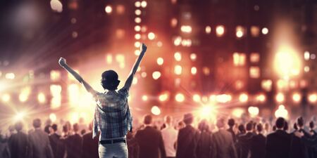 Back view of girl standing in stage lightsの写真素材