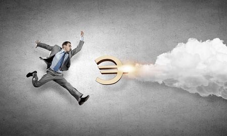 Young speedy businessman running in a hurryの写真素材