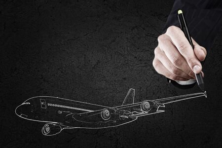 Close up of hand drawing airplane on black backgroundの写真素材