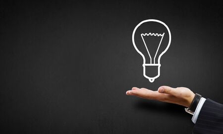 Huma hand presenting light bulb concept on palmの写真素材