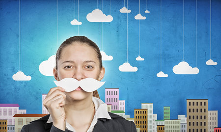 Young woman dressed up in suit and wearing fake mustacheの写真素材