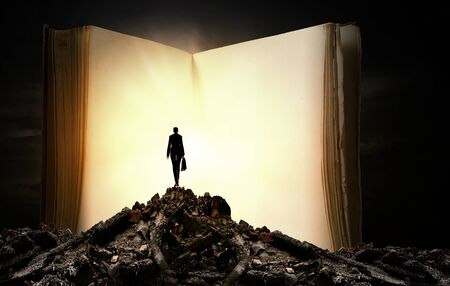 Big old opened book and miniature of businesswomanの写真素材