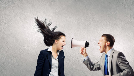 Young furious people screaming agressively in megaphoneの写真素材