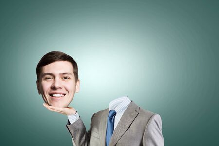 Young headless businesman holding his head in palmの写真素材
