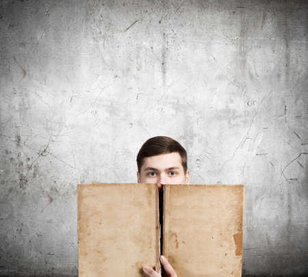 Young man with opened book in handsの写真素材