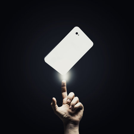 Human hand pointing at mobile phone with finger