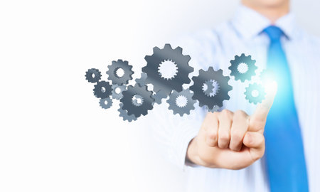 Close up of businessman touching gears mechanism with finger