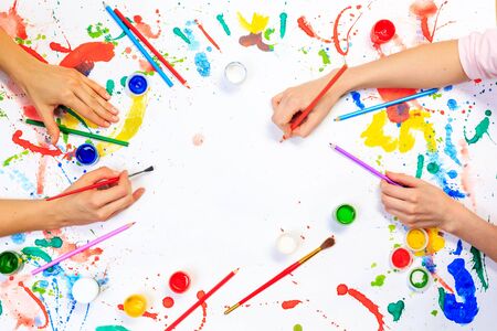 Close up of a human hands painting with gouache on white paperの写真素材