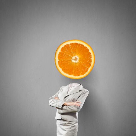 Headless businesswoman with orange instead of headの写真素材