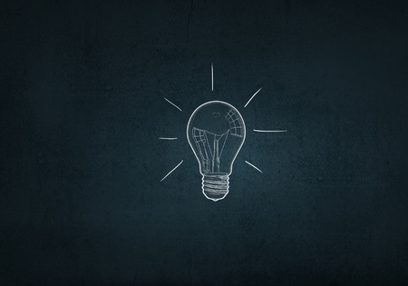 Light bulb with sketches inside on dark backgroundの写真素材