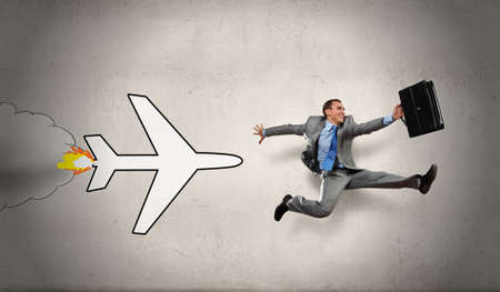 Overworked young businessman being late on airplaneの写真素材