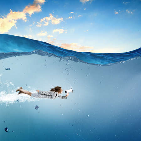 Young businesswoman in suit swimming in crystal blue waterの写真素材