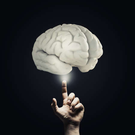 Human hand pointing with finger at brain iconの写真素材