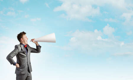 Young man making some announcement in trumpetの写真素材