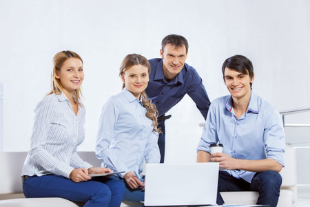 Four co-workers discussing business ideas in office