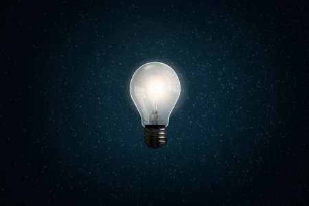 Glass glowing light bulb on dark background
