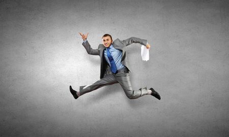Young speedy businessman running in a hurryの写真素材