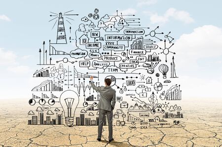 Back view image of businessman drawing sketches on wallの写真素材