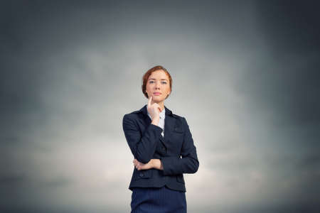 Young thoughtful businesswoman with finger on chinの写真素材