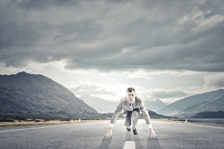Young determined businessman standing in start positionの写真素材