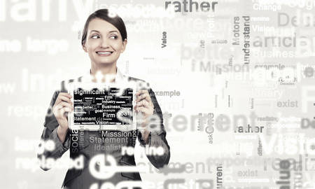 Beautiful young woman holding tablet pc and smilingの写真素材