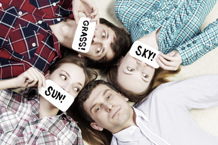 Group of young smiling people lying on floor in circle with phone symbols
