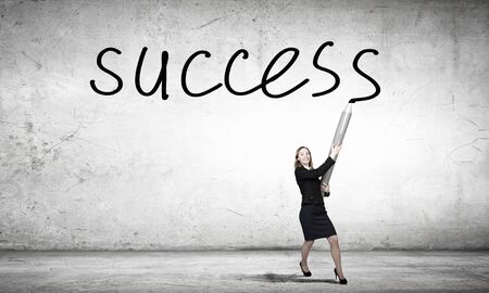 Businesswoman  drawing word success with huge pencilの写真素材