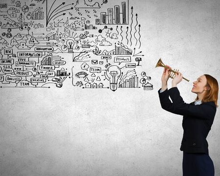 Young businesswoman in suit proclaiming something in hornの写真素材