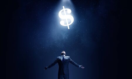 Businessman with hands spread apart and dollar sign aboveの写真素材