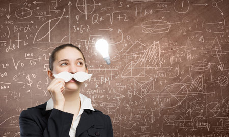 Happy cute girl trying male paper mustacheの写真素材