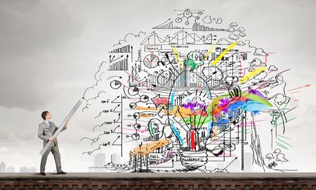 Businessman drawing plan strategy success with huge pencilの写真素材