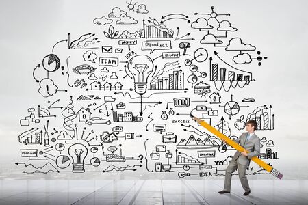 Businessman drawing plan strategy success with huge pencilの写真素材