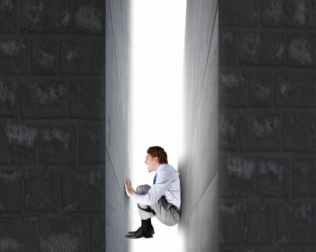 Businessman under pressure between two stone walls