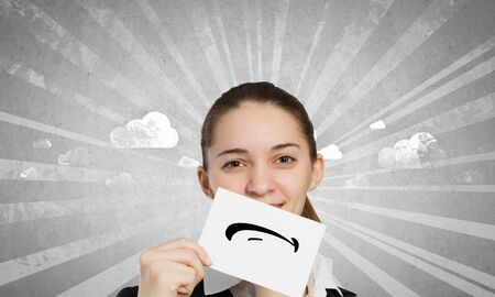 Young businesswoman holding paper with unhappy sad smileyの写真素材