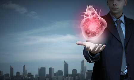 Close up of businessman holding digital heart in palmの写真素材