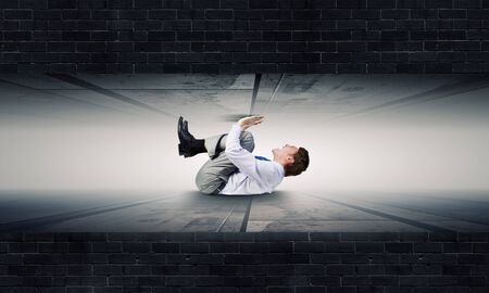 Businessman under pressure between two stone wallsの写真素材