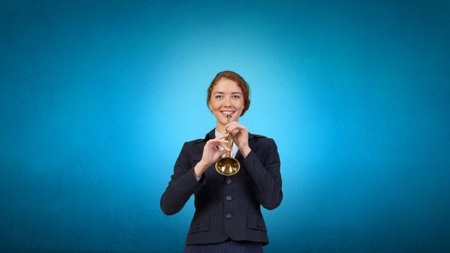 Cheerful businesswoman playing fife on color の写真素材