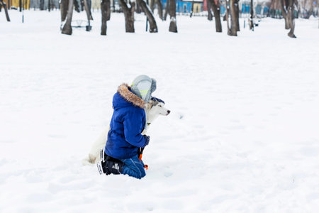 Kid of school age with dog in winter park