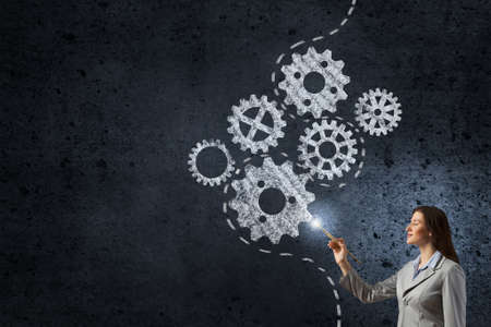 Young pretty businesswoman holding paint brush. Creativity conceptの写真素材