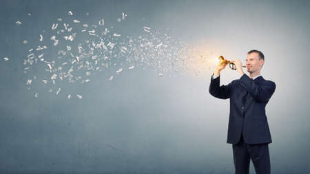 Young businessman in black suit playing fluteの写真素材