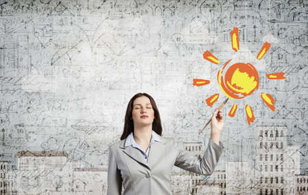 Young pretty businesswoman holding paint brush. Creativity conceptの写真素材