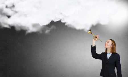 Young businesswoman in suit proclaiming something in hornの写真素材