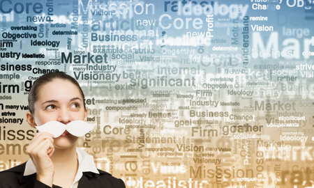 Happy cute girl trying male paper mustacheの写真素材