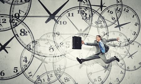 Concept of time with funny businessman running in a hurryの写真素材