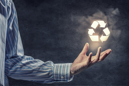 Businessman holding recycling sign in his handの写真素材