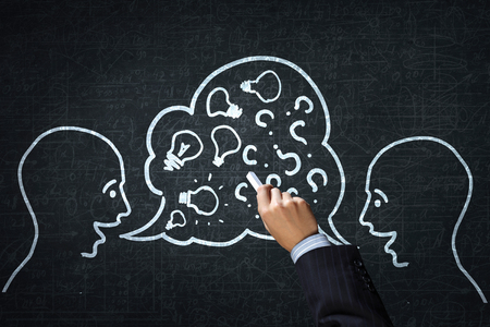 Close up of hand drawing dialogue between two on black wallの写真素材